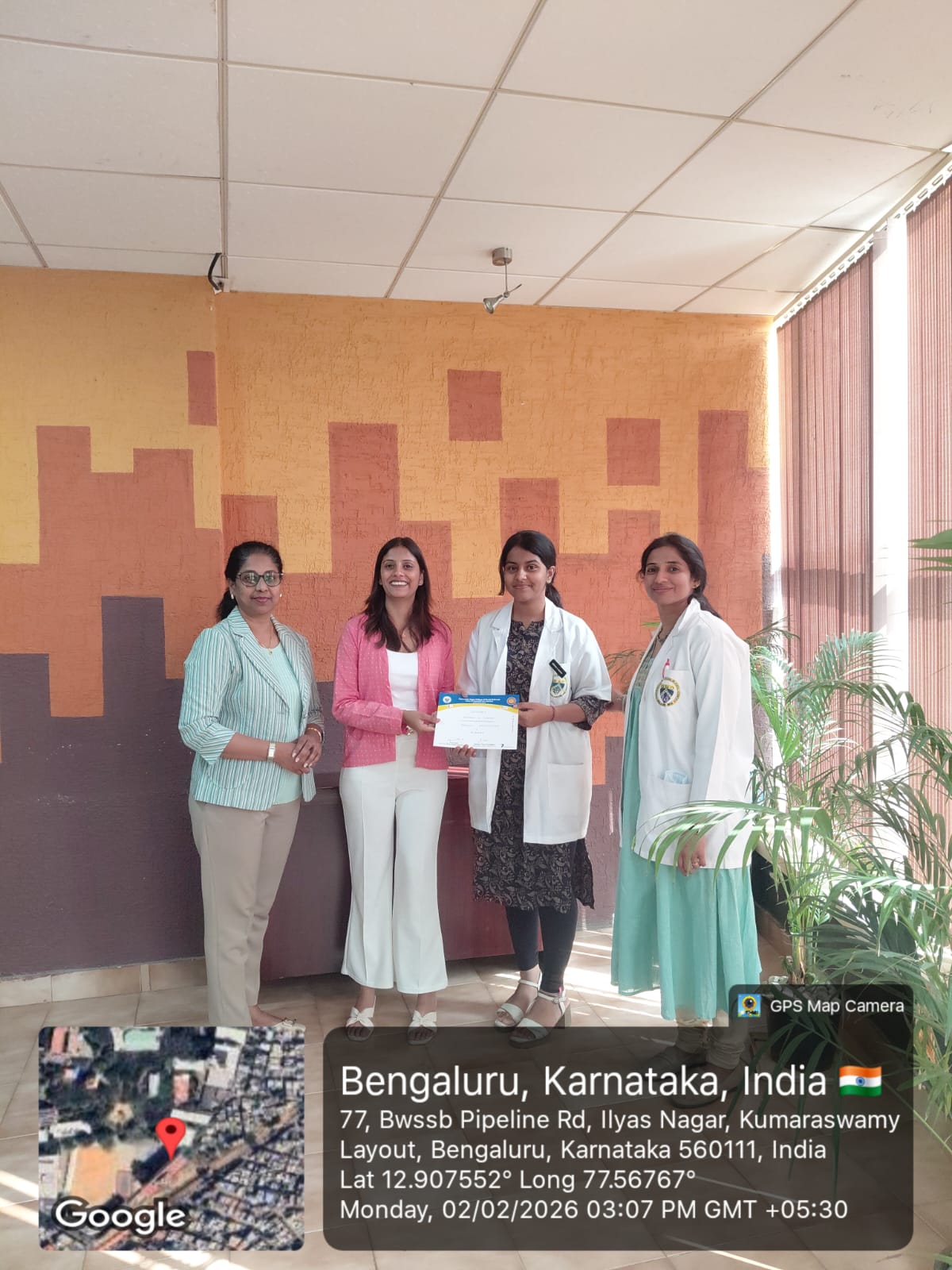 Faculty members and a student receiving a certificate.