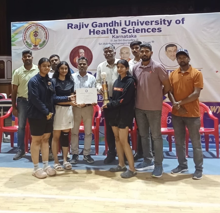 DSCDS Women's Badminton team receiving trophy and certificates on stage at RGUHS Tournament